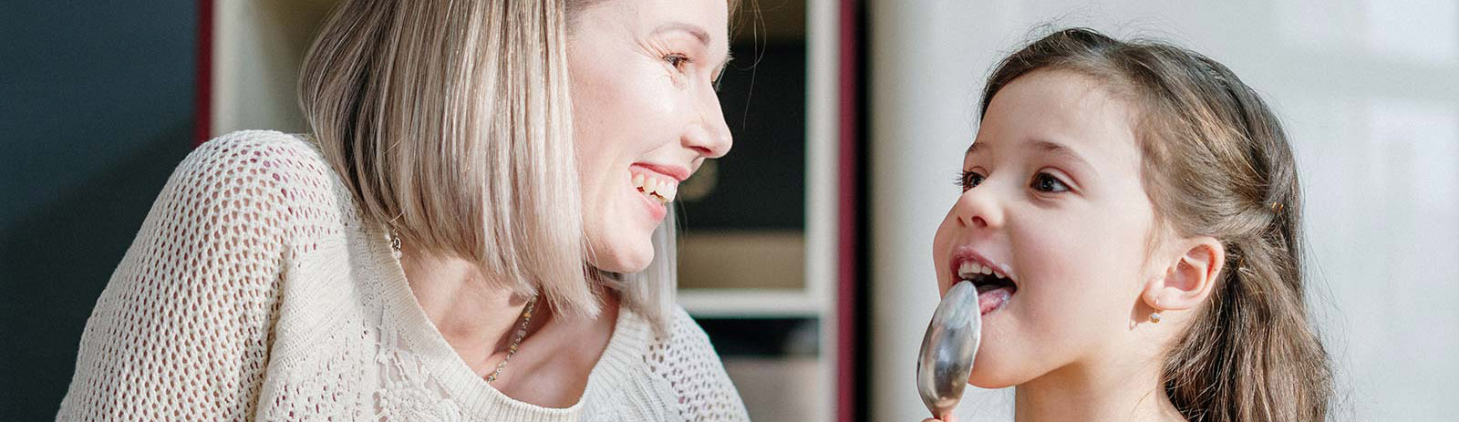 Girl and grandmother enjoying a treat in the kitchen