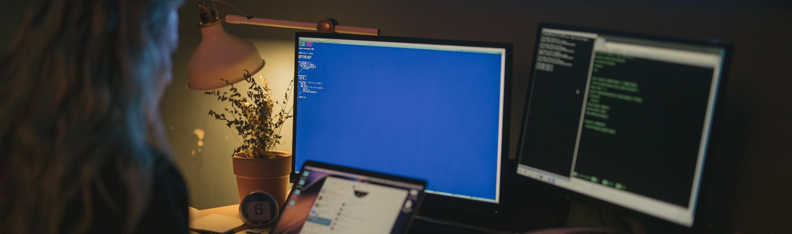 Woman Looking at computer screens and tablet